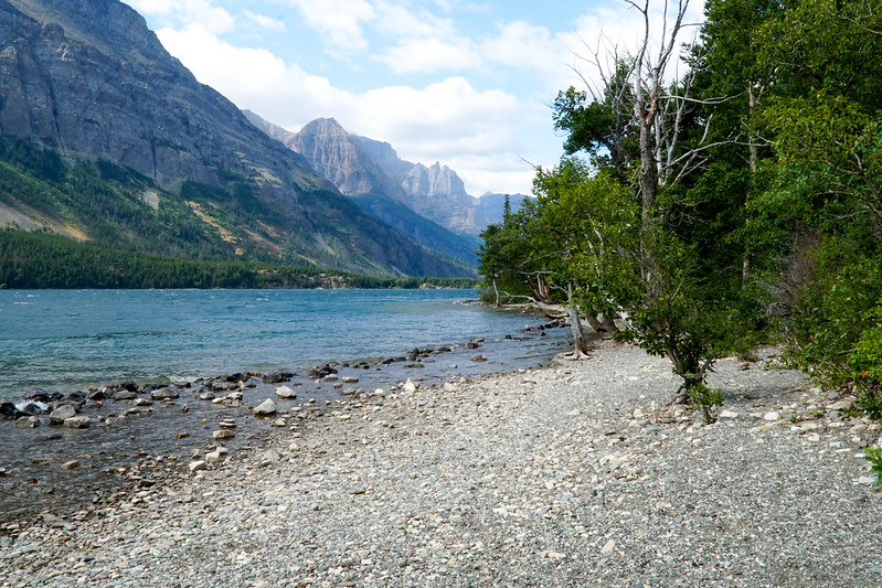 Lake shoreline in Glacier National Park with dramatic peaks in the background